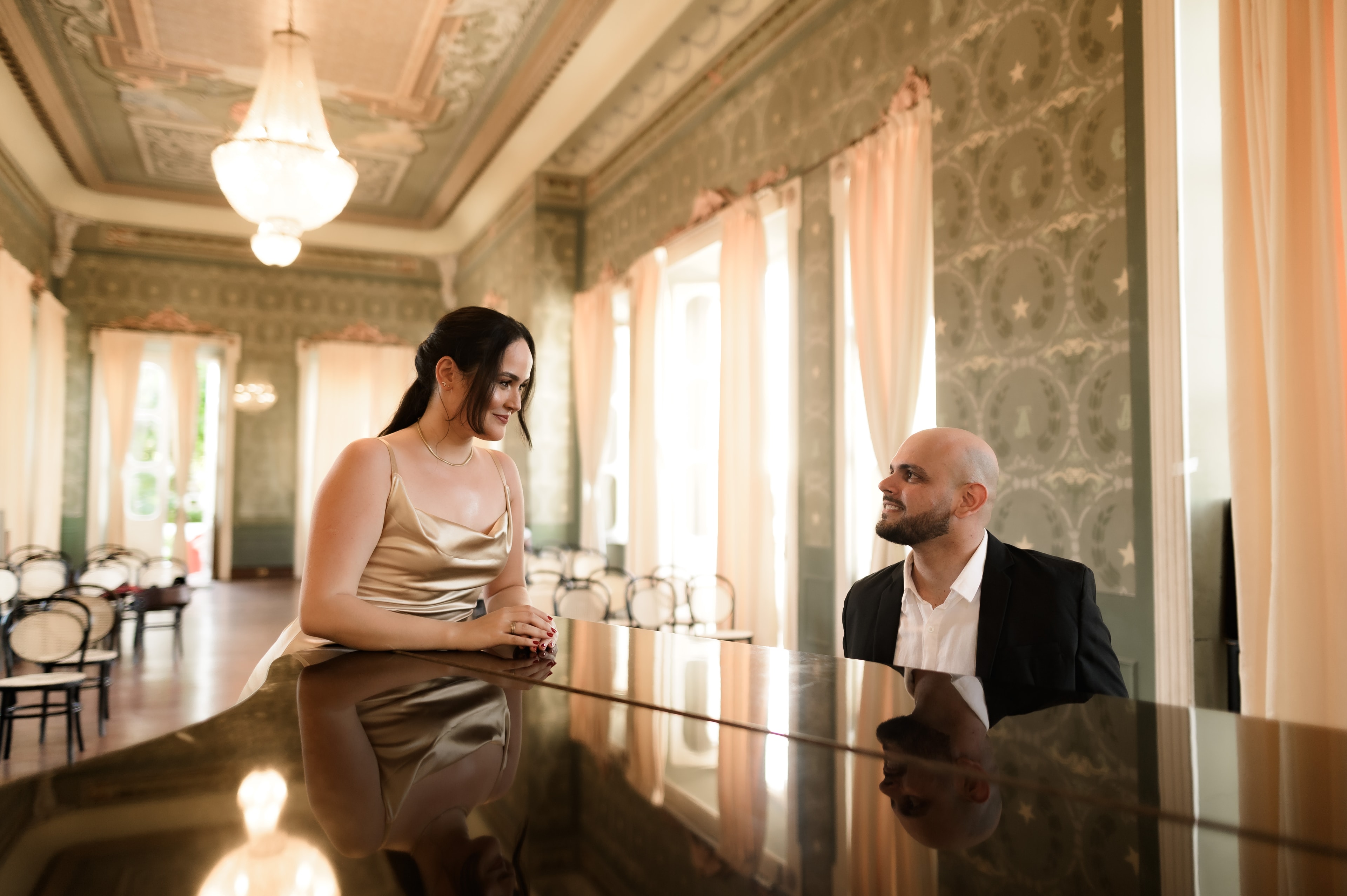Vitória e Matheus conversando ao piano